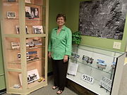 Dorothy Gunderson, of the Sunnyslope Historical Society and Museum, poses in front of the John C. Lincoln display in the historical building which once housed the “Peoples Drug Store”.