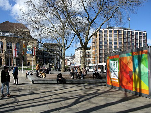 Platz der Alten Synagoge in Freiburg mit Stadttheater (links) und Infocontainer zum Stadtjubiläum