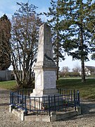 Vue d'un monument aux morts en forme de pyramide élancée et tronquée.