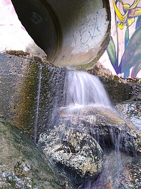 Rainwater flowing out of a pipe into a creek