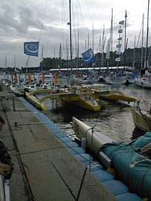 Foto di un trimarano giallo in un porto