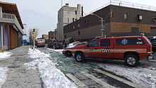 FDNY EMS Station 57 Supervisor's Command pickup, a 2012 GMC Extended Crew Cab 4X4 Diesel Pickup XLS, built by Odyssey Specialty Vehicles. Note, an FDNY engine and MERV in the background. FDNY Fire Engine fights the Brooklyn Paper Warehouse Fire (16420266492).jpg