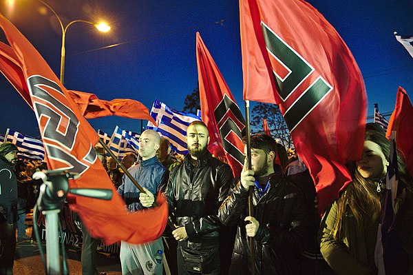 Golden Dawn members hold flags with the meander symbol at rally in Athens, March 2015