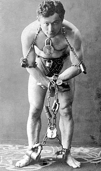 Houdini in a publicity shoot wearing chains and padlocks, 1899