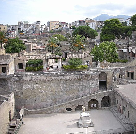 Ruins of Herculaneum in the foreground, modern Herculaneum (Ercolano) in the near background, Vesuvius in the distant background on the right
