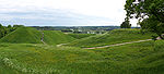 Mounds covered by grass. Stairs lead to some of the mounds.