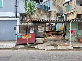 Lava Jato de rua, possui placas de preços e serviços com tipografia vernacular urbana.