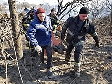 Emergency servicemen carry a dead body found under rubble in Malyn city, Zhytomyr Oblast, after a Russian airstrike on 8 March 2022. Malyn after Russian shelling, 9 March 2022 (01).jpg