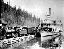 Nakusp meeting train of the Columbia and Kootenay Railway on the inclined wharf at Robson Nakusp (sternwheeler) at Robson, BC circa 1896.jpg