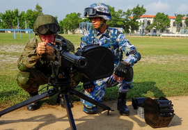 Китайский морской пехотинец инструктирует российского солдата в обращении с QLZ-04