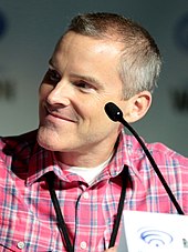 Young, smiling man facing forwards