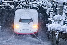 融雪スプリンクラーの作動する越後湯沢駅に入線する新幹線E4系電車