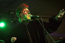 Arthur Brown was a major influence on Cooper. During live performances and in the promotional video, Brown performed the 1968 song "Fire" wearing black and white makeup (corpse paint) and a burning headpiece. The Crazy World of Arthur Brown (15559408036).jpg