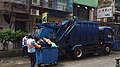清潔工正加緊清理積滿的大型垃圾桶