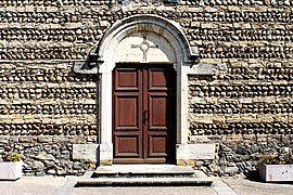 Entrance door and surrounding stone stone wall of Église de l'Immaculée-Conception d'Haut-Biol