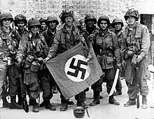 101st Airborne troops posing with a captured Nazi vehicle air identification sign two days after landing at Normandy. 101st Airborne Division - WW2 01.jpg