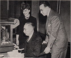 Mint Director Nellie Tayloe Ross (left) looks on as two members of the 1942 Assay Commission weigh a coin. 1942 Assay Commission weighing.jpg