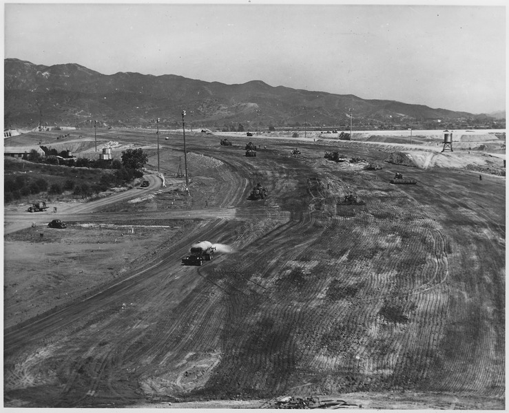 File:A general view showing the construction of the compacted earth embankment looking east along the axis of the dam from... - NARA - 295313.tif