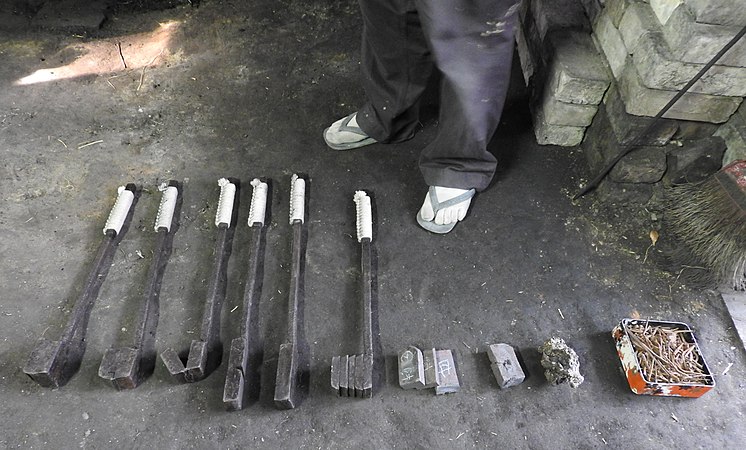 Français : De droite à gauche, transformation du fer (clous de récupération de vieilles maisons de 2 ou 3 siècles) en acier brut (hagane), puis en brique d'acier feuilletée plusieurs fois.Présenté par le forgeron Tsuneharu Matsuda, à Tsubata (Ishikawa)