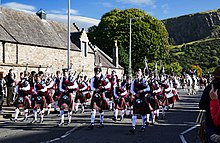 A pipe and drum band leads the Riding of the Marches past the Palace of Holyroodhouse in Edinburgh, Scotland, on Sept. 15, 2019. Edinburgh Riding of the Marches 2019.jpg