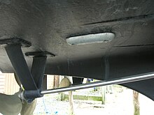 Zinc sacrificial anode (rounded object) screwed to the underside of the hull of a small boat. Electrode protecting a screw.jpg