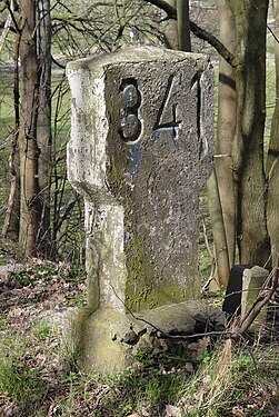 milestone at former railway line which has turned into a forrest stripe