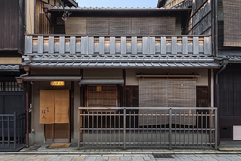 Facade of a dwelling with sudare, wooden balustrades and yellow lamp, Shinbashi-dori, Gion, Kyoto, Japan