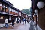 Small street lined by wooden two-storeyed houses.
