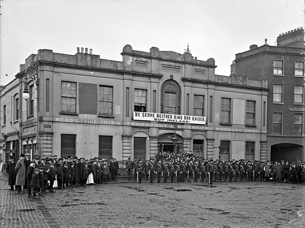 Members of the Irish Citizen Army outside Liberty Hall, under the slogan "We serve neither King nor Kaiser, but Ireland"