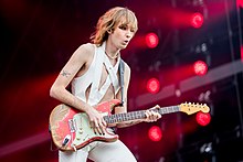 Photographie de Thomas Raggi jouant de la guitare en concert.