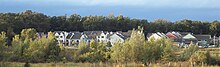 Sunward Cohousing panorama illustrating greenspace preservation, tightly clustered housing, and parking on periphery, 2003. SunwardPanorama2003.jpg