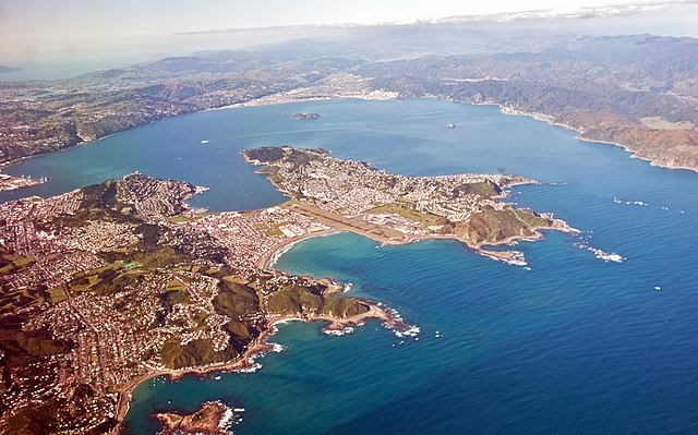 Looking north-east over Wellington Harbour from above Cook Strait Left to right: Lambton Harbour, Miramar Peninsula and the harbour entrance