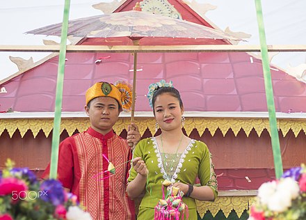 Dai man and woman dressed in traditional clothing for Songkran