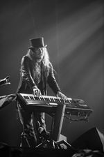 photo en noir et blanc d'un homme avec un chapeau jouant du clavier sur une scène