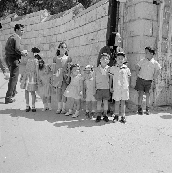 File:Acht chique aangeklede kinderen op een rij, vergezeld van een oude vrouw, Bestanddeelnr 255-3287.jpg