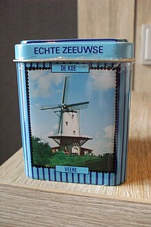 Jasnoniebieska puszka w kształcie prostopadłościanu. Na widocznej ściance znajduje się napis "Echte Zeeuwse de Kol" oraz zdjęcie wiatraka.