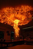 The steam-oil aerosol, suddenly spread out and exposed to air, will all ignite at once, making a large fireball. Indoors, this can ignite the ceiling space