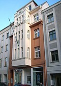 Apartment building in closed development, with shop and flag holder