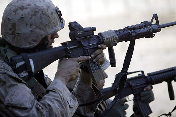 A U.S. Marine looking through an ITL MARS combination red dot and laser sight mounted on his M16A4 MWS rifle during the Second Battle of Fallujah, 200