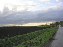 Campo arato piatto sotto un cielo grigio