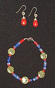 Conjunto colar e brinco confecionado em pedras semipreciosas. As contas verdes esféricas são serpentina de origem russa. Também são usados ​​jaspe (vermelho) e fluorite (azul).