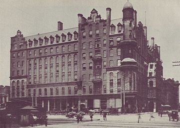 A black and white photograph of a seven-story brick hotel
