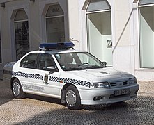 Lisbon Municipal Police Nissan Almera painted white, with chequered black and white side stripes.