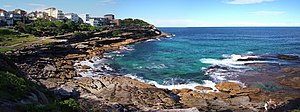 Mackenzies Bay, as a rocky inlet, in April 2013. The headland in the background is Mackenzies Point. Both are on the route of the Bondi to Coogee urban coastal walk,[14] which is visible in the upper-left.