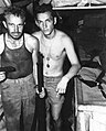 Two U.S. Marines display a captured Japanese rifle and pistol soon after re-embarking on the submarine USS Nautilus following the raid on Makin on August 17-18, 1942.