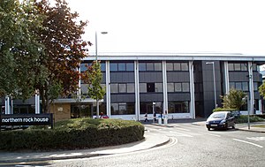 A three-storey black and grey building; the headquarters of the bank.