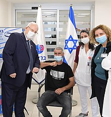 Reuven Rivlin with the first vaccinator in Phase B of the Israeli Vaccine of the Israeli Biological Institute, January 2021 (GPOABG 4084).jpg