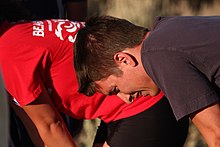 The tripod position may be adopted by people experiencing respiratory distress or who are simply out of breath. Runners panting.jpg