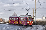 SGP E1 o numerze taborowym #945 oklejony w barwy ZTM zmierza ulicą Katowicką w kierunku centrum przesiadkowego Chorzów Rynek.