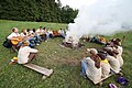 English: Scouts in uniform by fire. Čeština: Skauti v krojích u ohně.